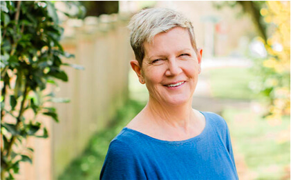 headshot of suzanne mager in front of trees