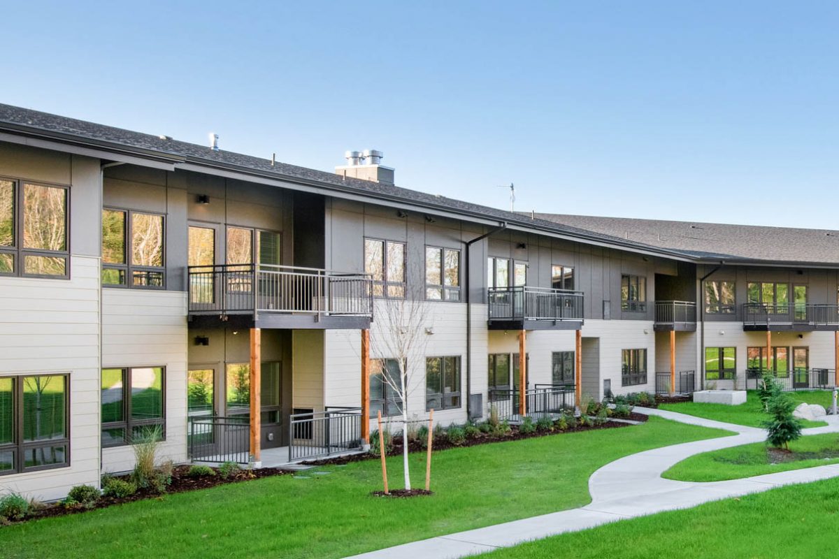 brownstone apartment building view with green grass