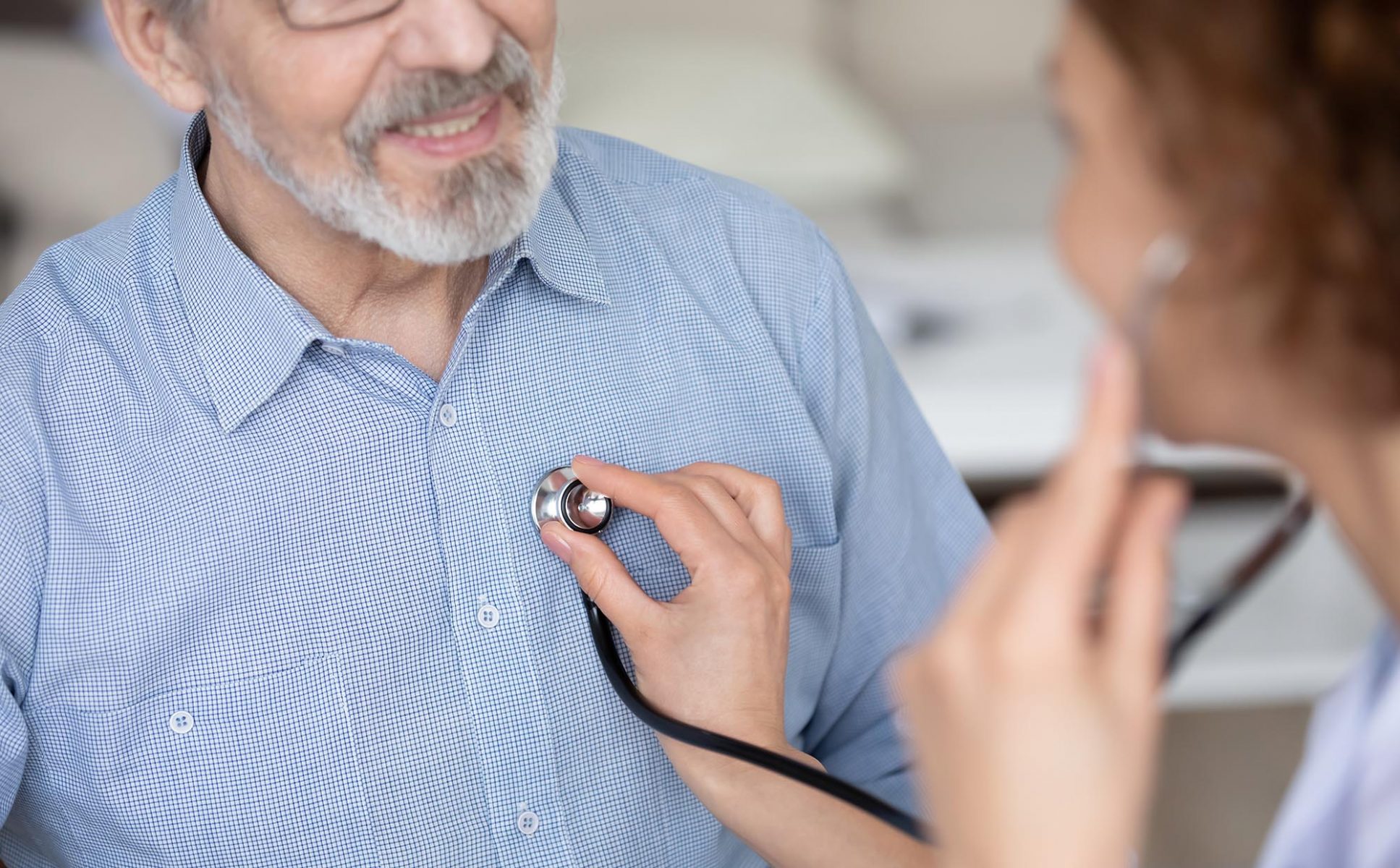 Doctor listening to senior man's heart with stethoscope