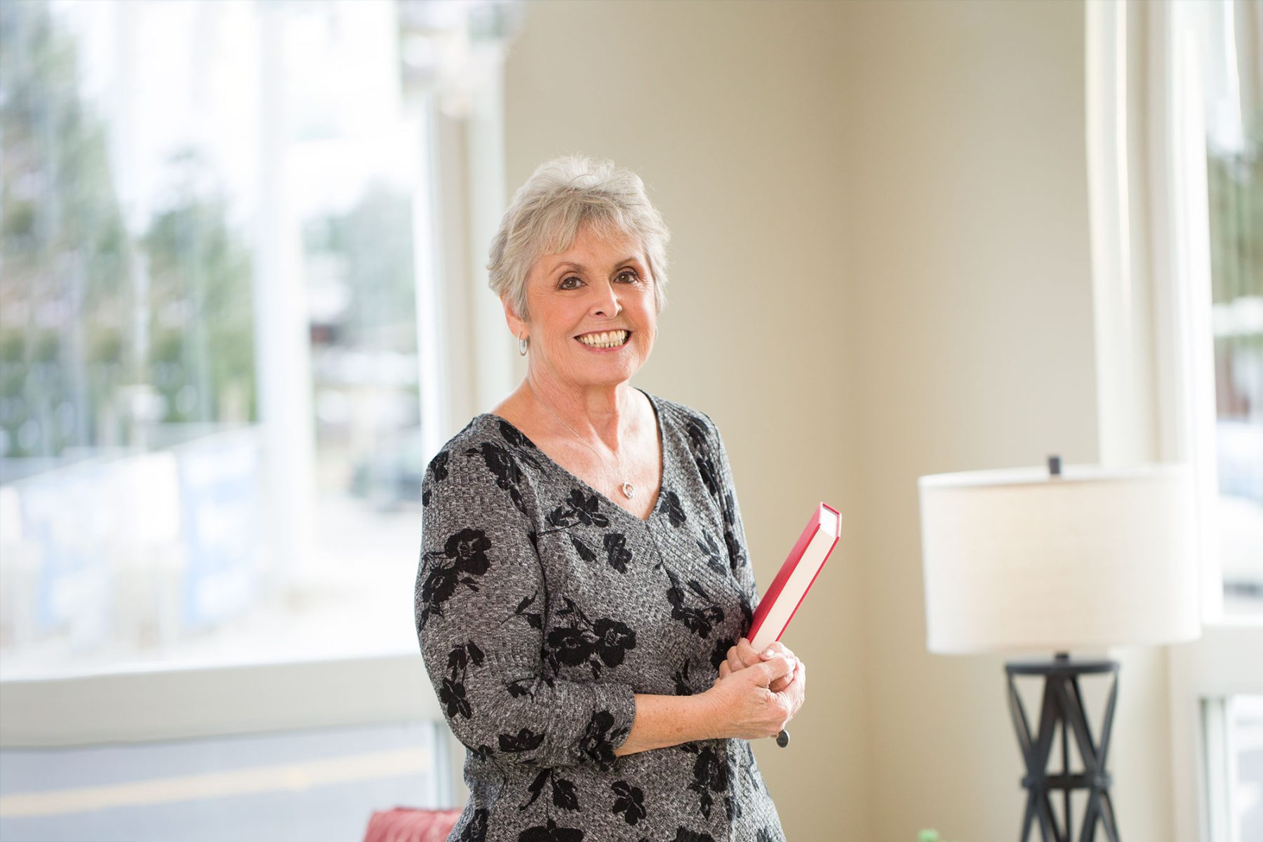 Happy senior lady holding a book