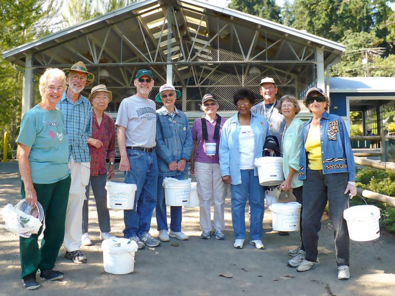 group of Wesley residents smiling with buckets of blueberries on blueberry farm