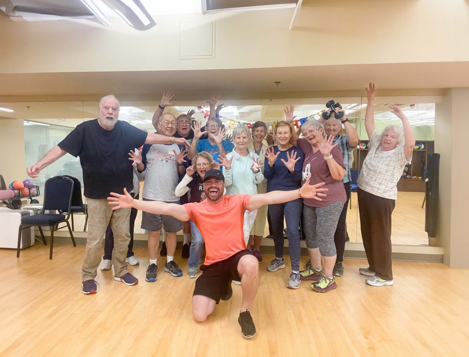 Happy senior residents posing for a fun picture in their fitness class