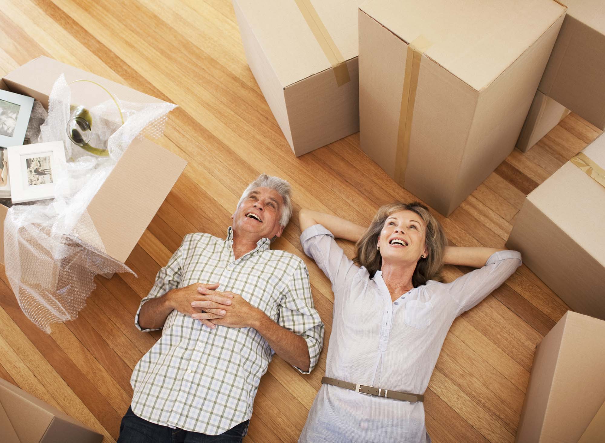 senior couple happy move packing boxes downsizing