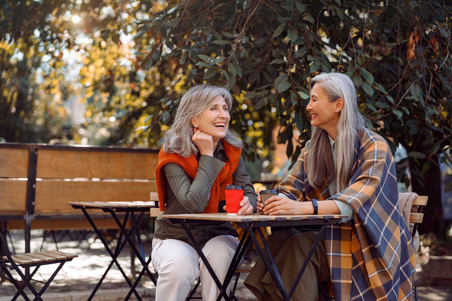 Older Adult Women enjoying coffee together in the fall