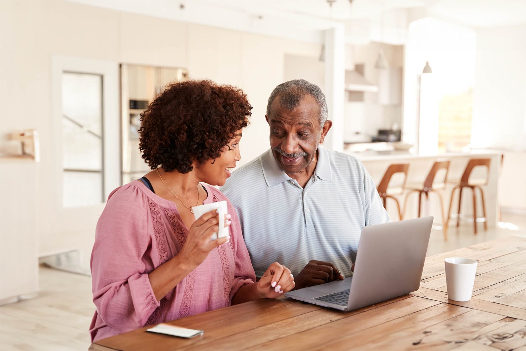 older couple reviewing finances at table with laptop