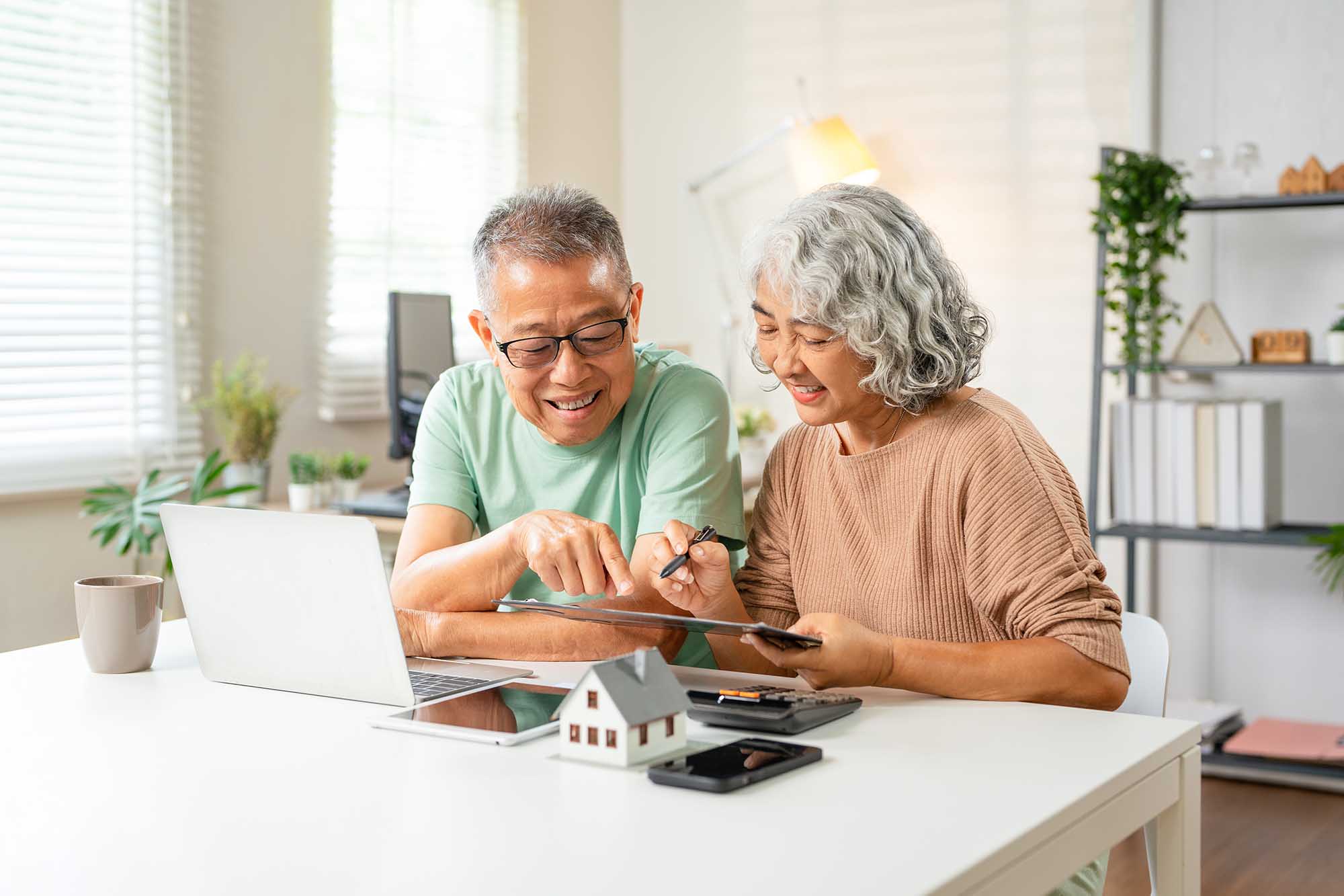 senior couple financial planning in kitchen happy